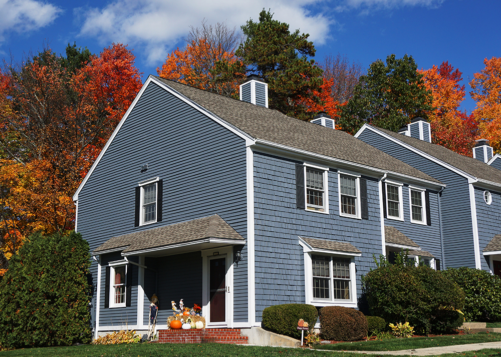 Blue northeastern house painted blue exterior painting autumn leaves in the background