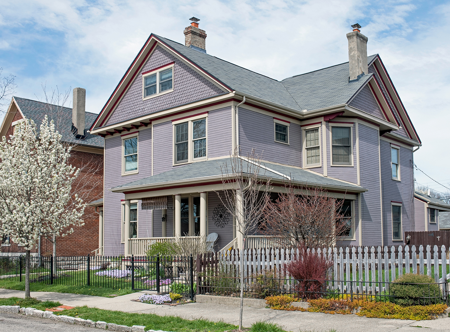 Exterior painting service for an old house with purple paint and beige trim