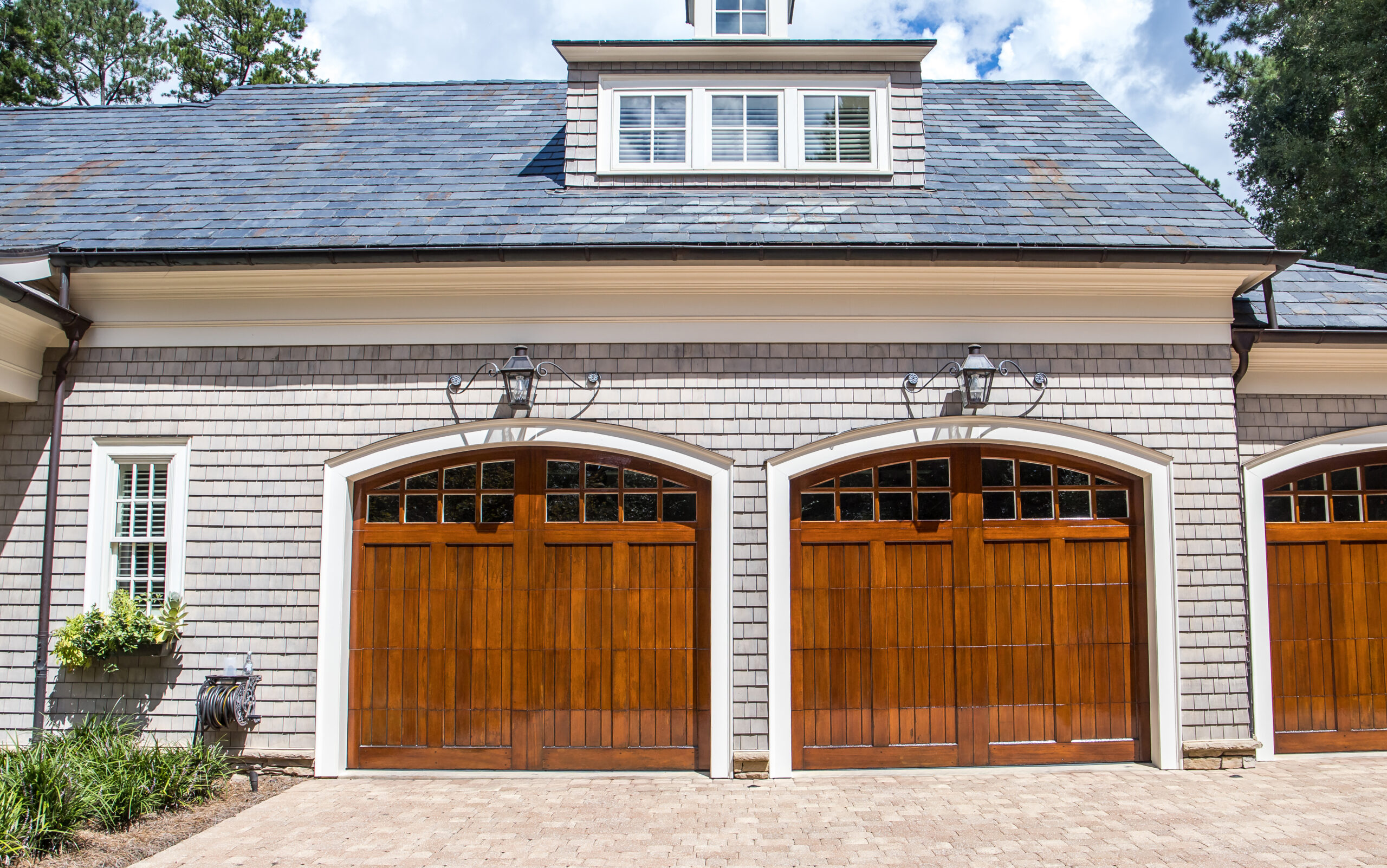 Gray painted house exterior with dark brown stained garage doors