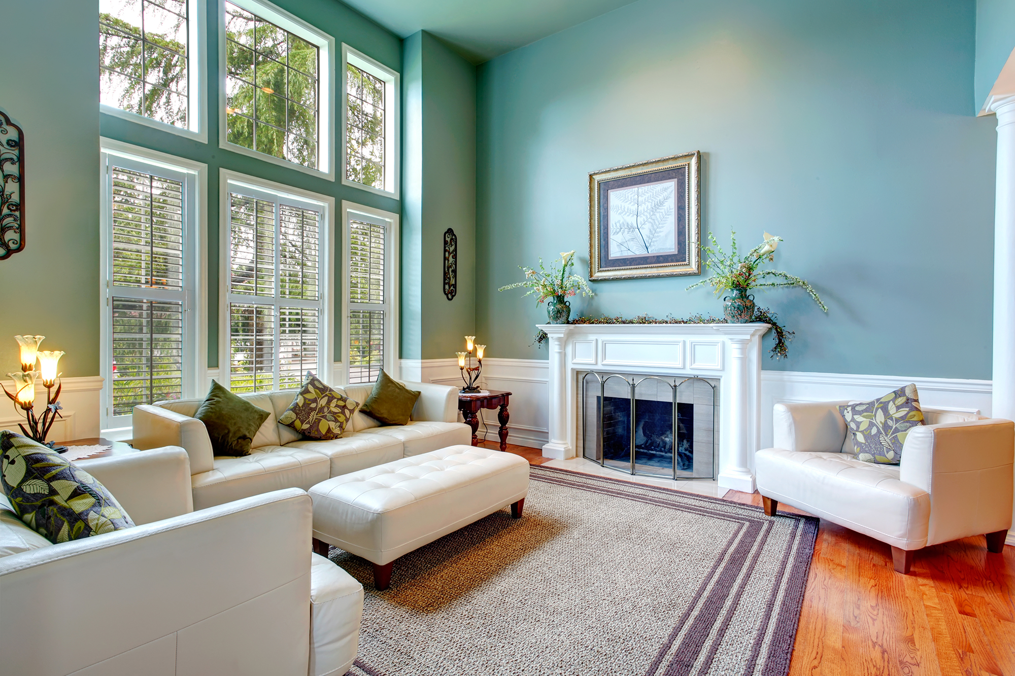 Living room with teal painted walls and white painted fireplace and trim