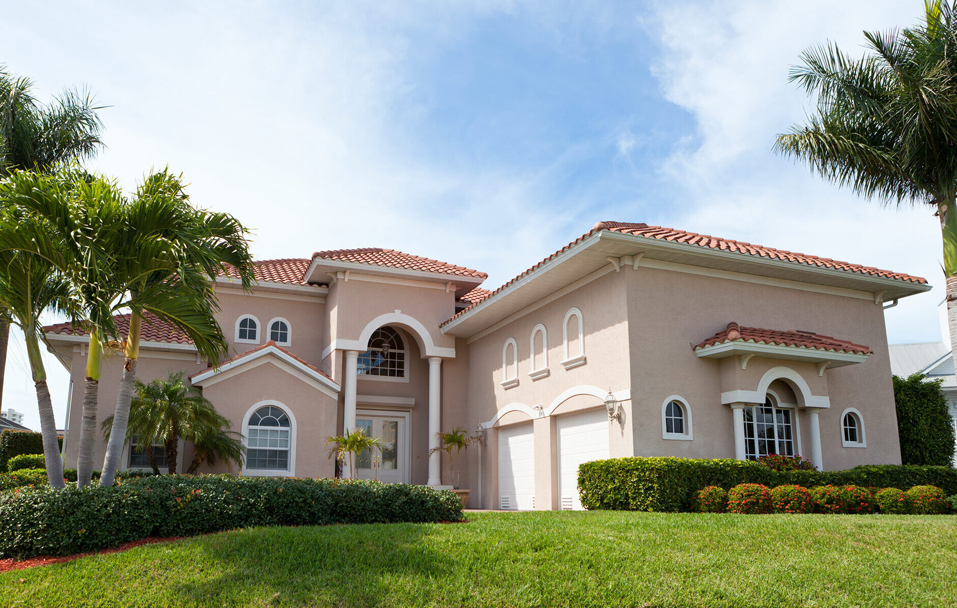 Large stucco home with light pink painted exterior